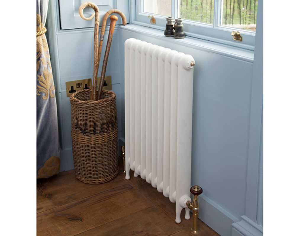 cast iron radiator painted in parchment white with brass valve in blue room